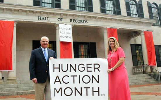 Monmouth County Freeholder Director John P. Curley (left) and Freeholder Serena DiMaso (right) hold the Hunger Action Month sign in front of the Hall of Records.
